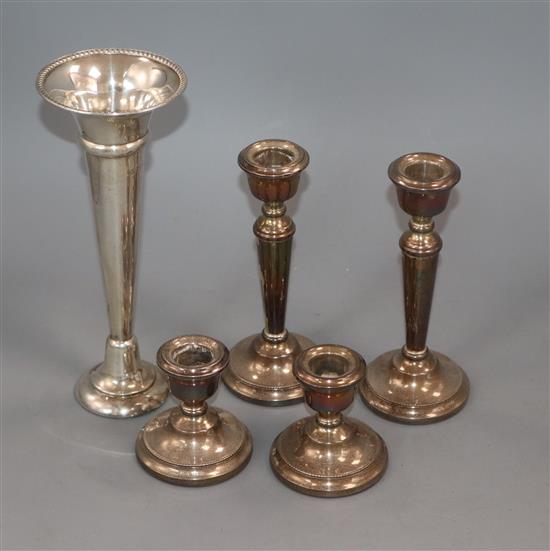 Two pairs of silver candlesticks and a silver trumpet vase.